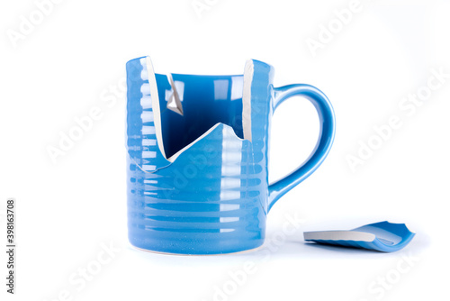 Broken blue mug with a shattered piece laying next to it