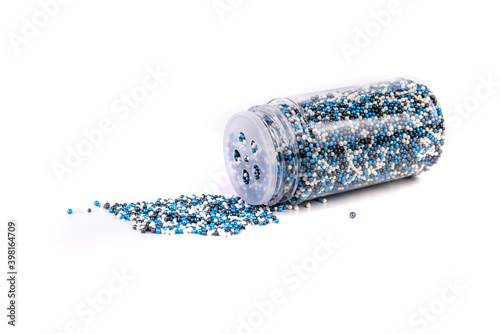 Картината върху платно White blue and black sprinkles spilled from a container isolated over white back