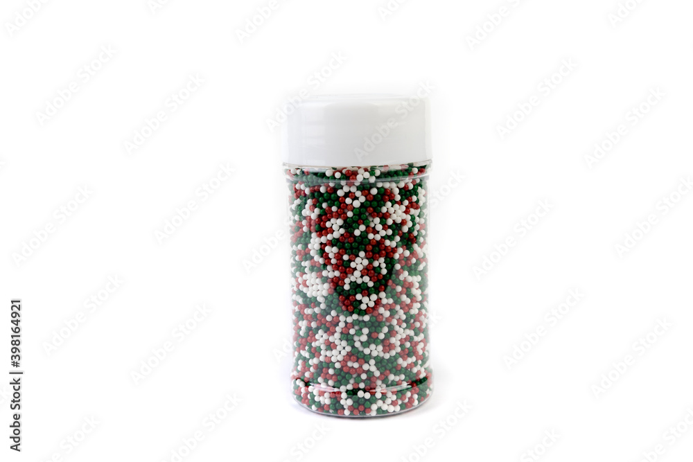 Red white and green sprinkles in a container isolated over white background Red white and green sprinkles in a container isolated over white background