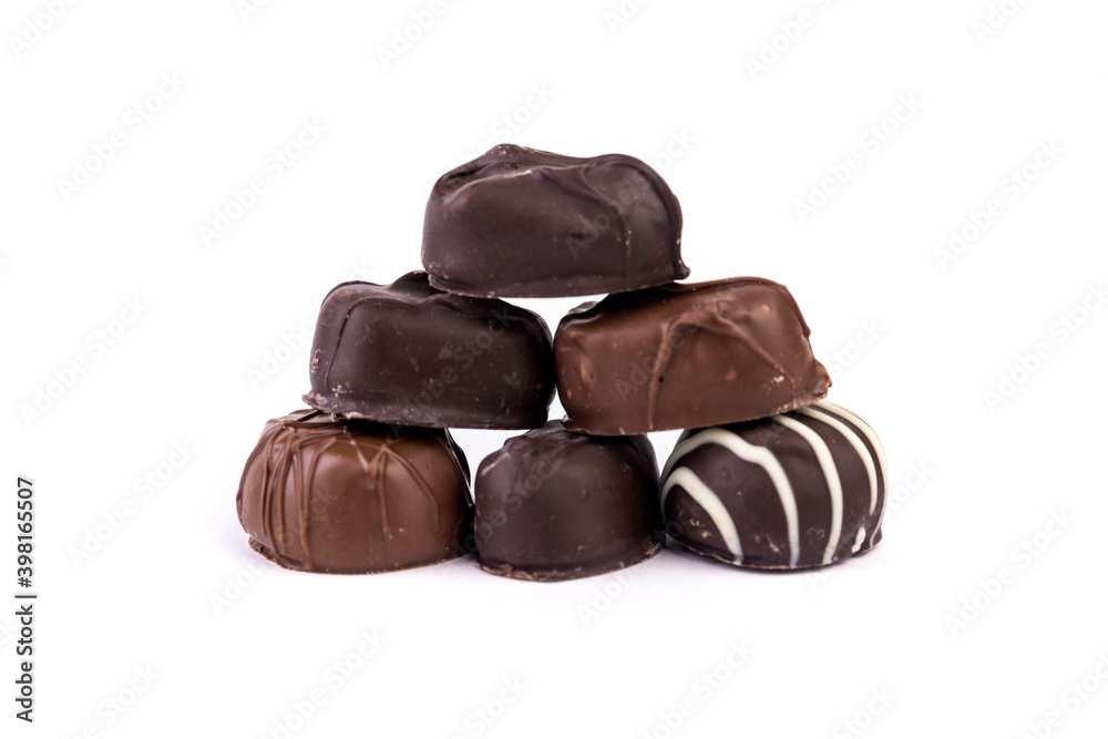 Molded filled chocolates stacked in a pyramid isolated over white Molded filled chocolates stacked in a pyramid isolated over white