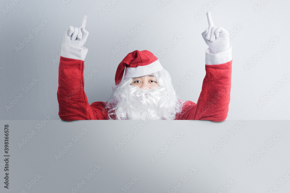 Naklejka premium Asian man in Santa costume showing an empty board
