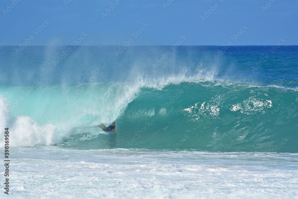 Obraz premium Bodyboarder on the Northshore of Oahu during large winter wave swells in Hawaii, USA. 