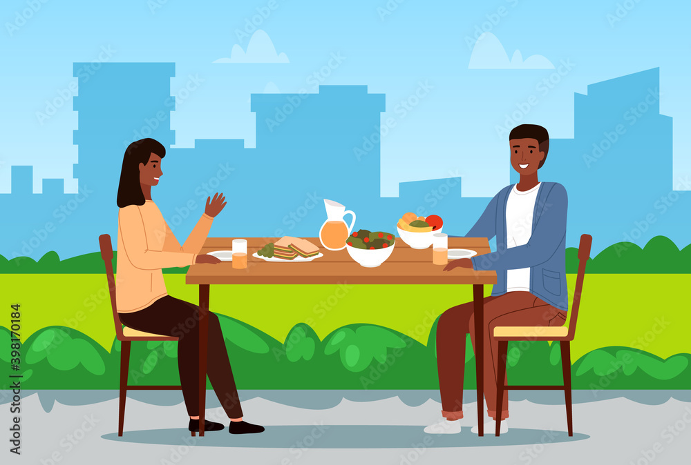 Table with fruit, salad and sandwiches. Couple eating natural food. People are having dinner outdoors. Characters on a date in the park. Afro American people communicate and spend time together