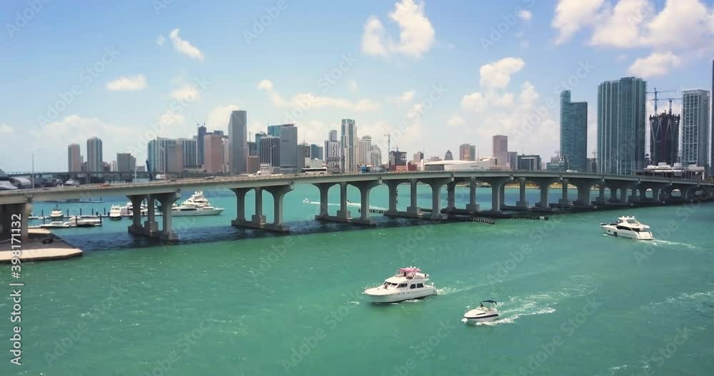 beautiful aerial shot of miami skyline with the bay, boats, and a bridge
