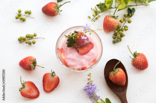 Fototapeta Naklejka Na Ścianę i Meble -  healthy foods yogurt from fruits strawberry for diet weight with purple flower decoration flat lay style on background white 