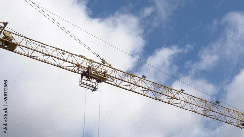Construction crane against the blue sky and the houses under construction. Yellow hoisting tower crane on top of a construction skyscraper. machinery crane construction, tool of building industry
Construction crane against the blue sky and the houses under construction. Yellow hoisting tower crane on top of a construction skyscraper. machinery crane construction, tool of building industry