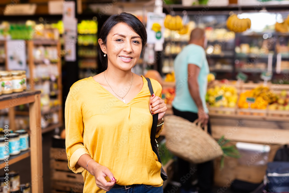 Positive woman in grocery store interior closeup