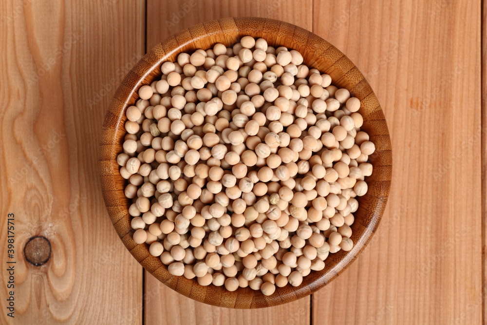 Whole yellow peas in wooden bowl