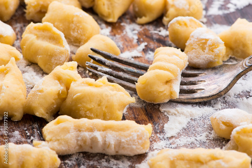 Uncooked homemade potato gnocchi with fork