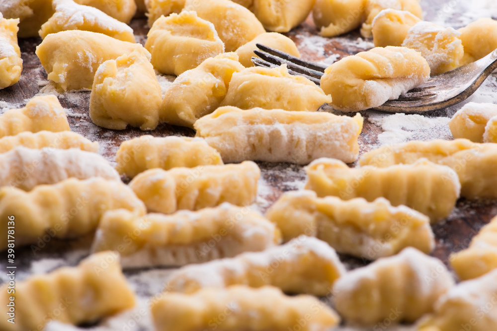 Uncooked homemade potato gnocchi with fork Uncooked homemade potato gnocchi with fork