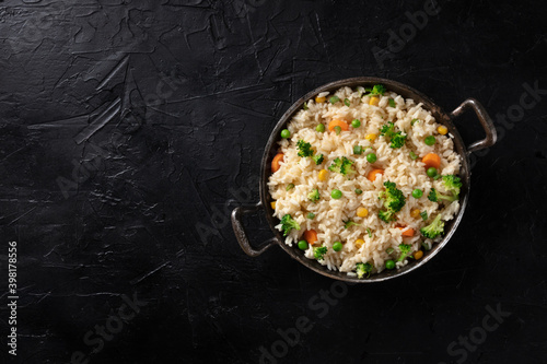 Vegan rice, stir fried, shot from the top on a black background with copyspace