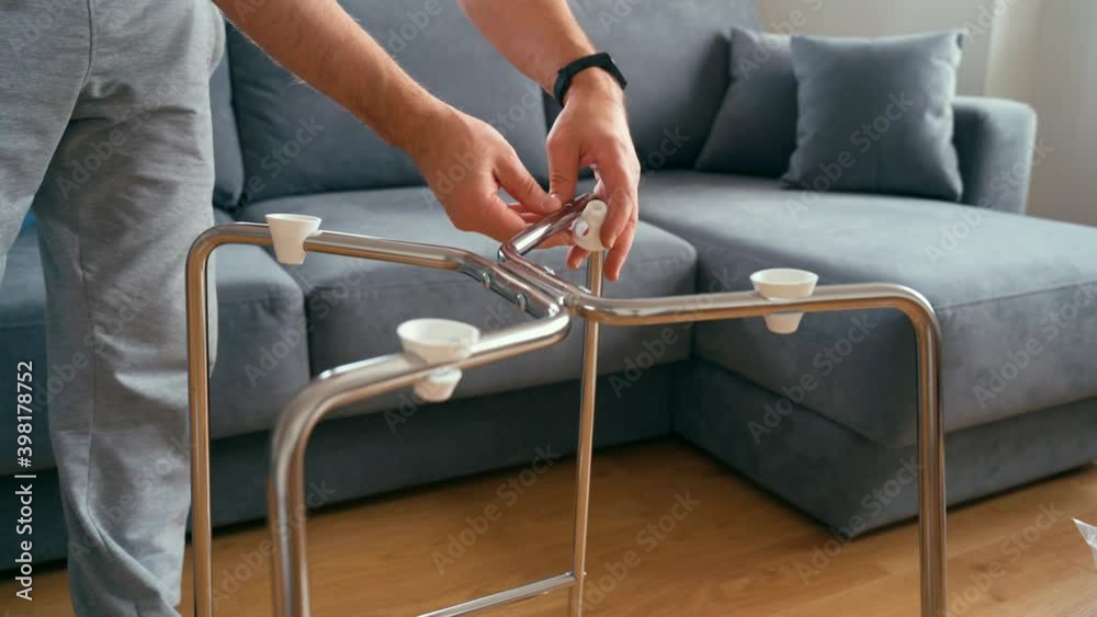 A man puts plastic pads on the chair frame to fit the seat. Assembling the chair A man puts plastic pads on the chair frame to fit the seat. Assembling the chair