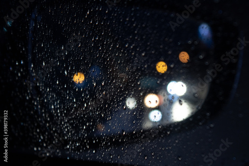 blurred lines on rearview and rain drops over window
