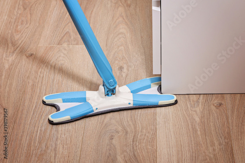 A man washes the floors with a mop in the room. Under the bed. Cleaning.