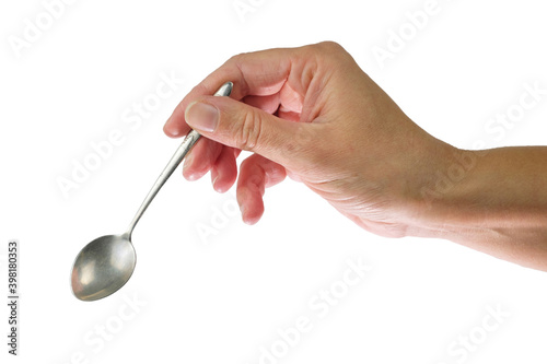 Female's hand holding steel spoon in the right hand, isolated on a white background photo