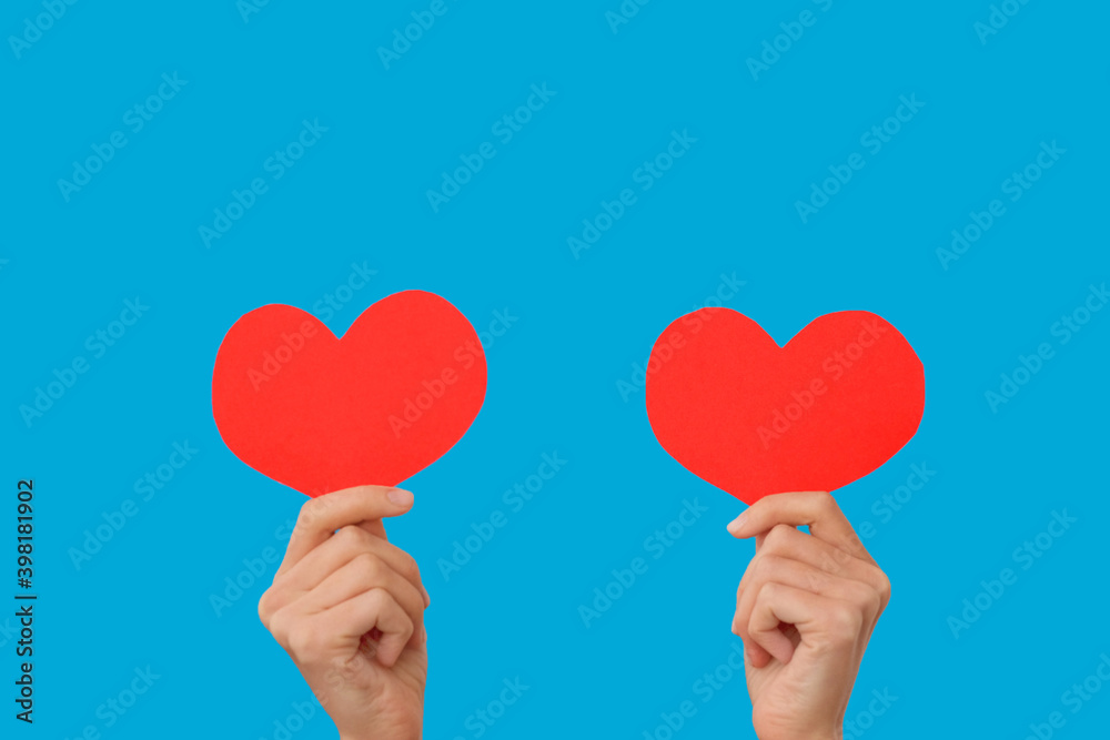 Female blogger hold in hands little red hearts, dancing to music rhythm isolated on blue background. Like blogging blog social network tenderness concept. Valentines day international women Female blogger hold in hands little red hearts, dancing to music rhythm isolated on blue background. Like blogging blog social network tenderness concept. Valentines day international women