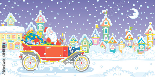 Santa Claus with a magic bag of winter holiday gifts driving his retro car down a snow-covered street with colorful houses of a pretty small town on a snowy moonlit night