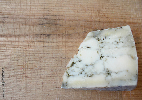 slice cheese on a Board cut delicious farm cheese in parts, in the form of a marble, a plate with different Derby cheeses green