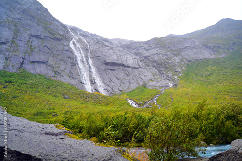Cliff and waterfalls in the Jostedalsbreen National Park in Norway in rainy and foggy weather. The Glacier Briksdalsbreen is one of the most accessible and best known arms of Jostedal glacier. 