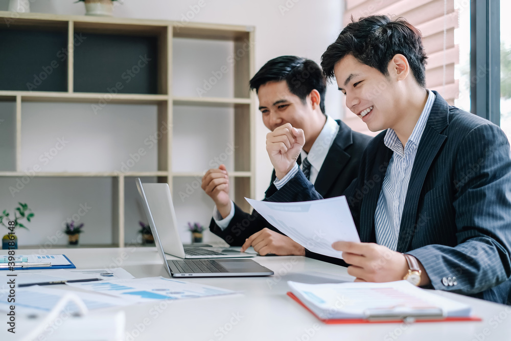 Two successful young Asian businessman working together in a modern office.