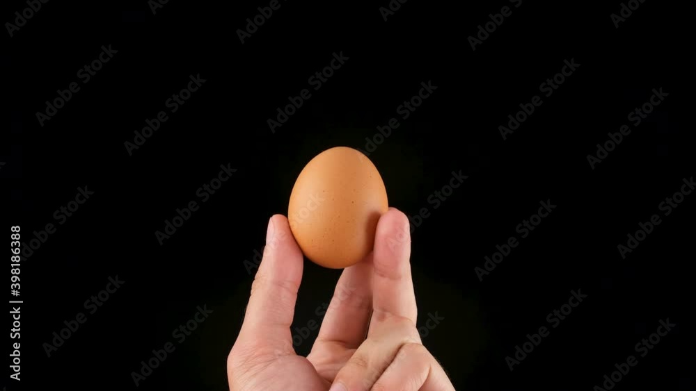 Holding an egg in her hands. Black background. Close up Holding an egg in her hands. Black background. Close up
