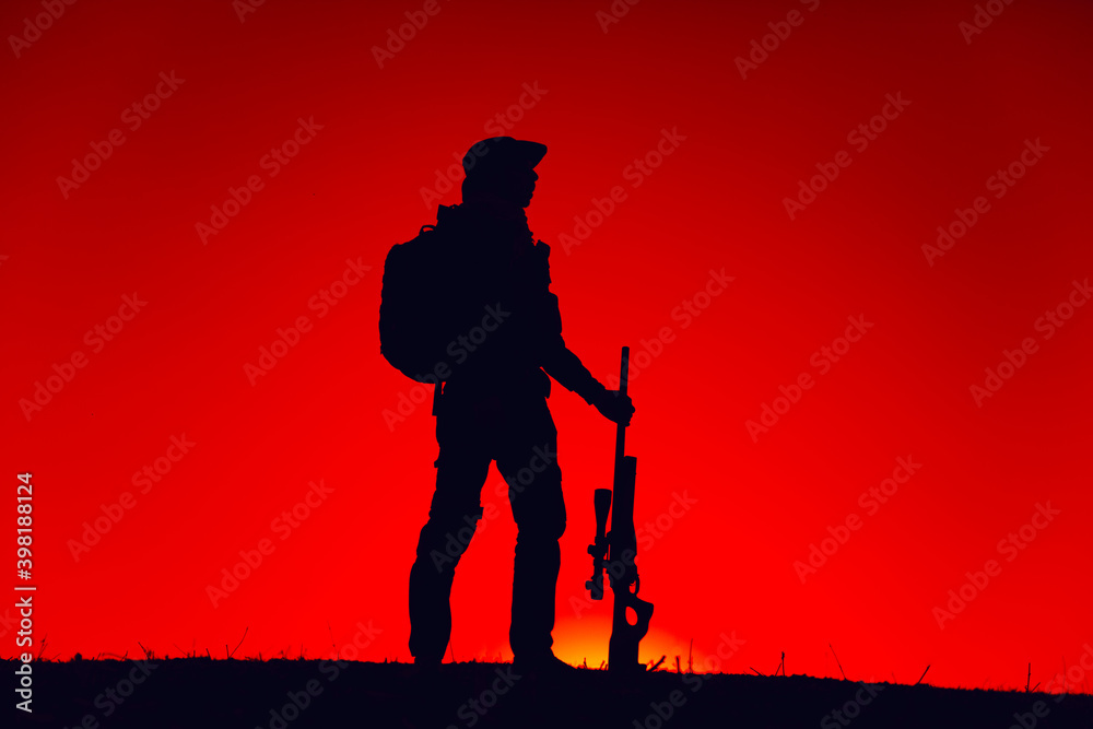 Silhouette of army special forces sniper standing with rifle on ...