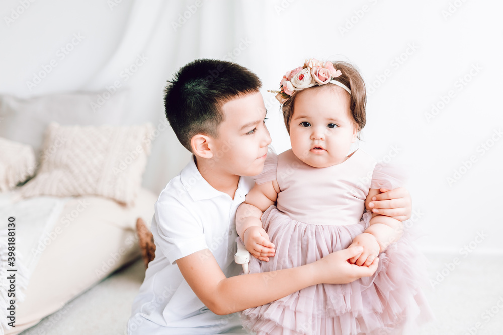 My brother holds my little sister's hand and hugs her. Happy happy children, on a nice soft background My brother holds my little sister's hand and hugs her. Happy happy children, on a nice soft background