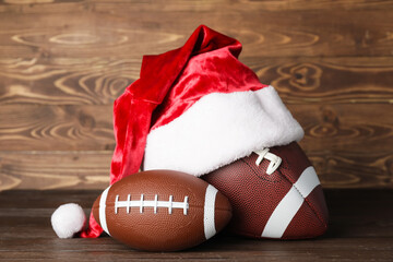 Santa hat with rugby balls on wooden background