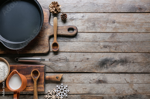 Ingredients for Christmas bakery and kitchen utensils on wooden background