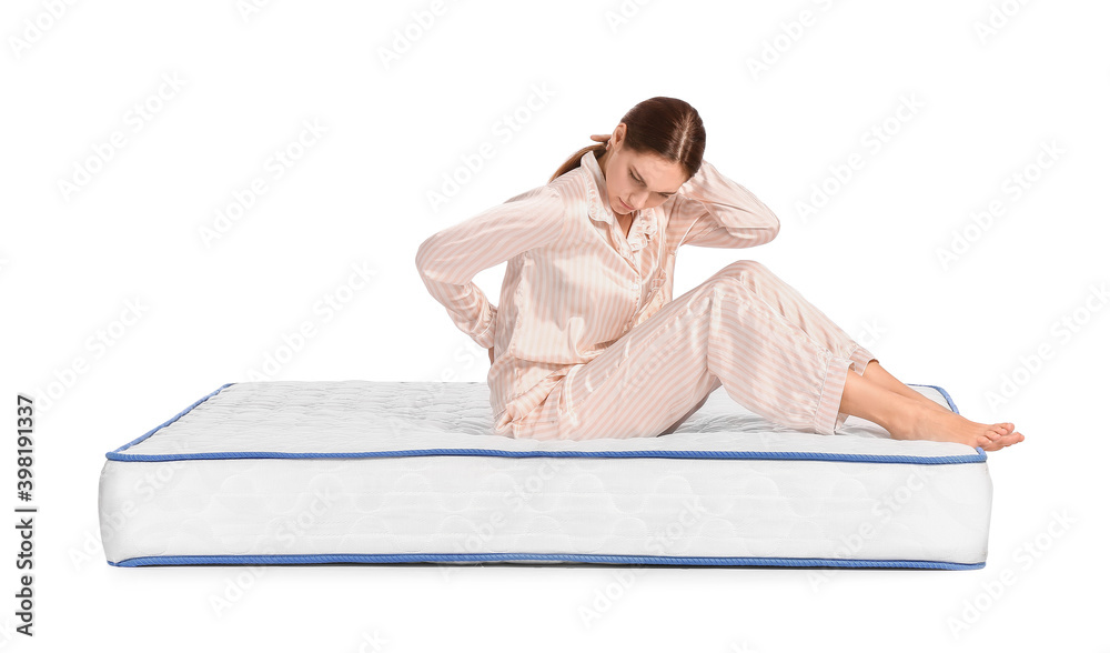 Young woman suffering from pain on mattress against white background Young woman suffering from pain on mattress against white background