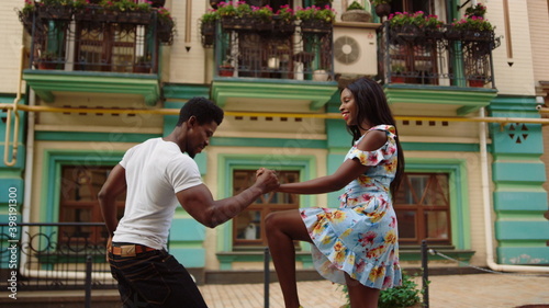 Happy african dancers curling in dance in city. Afro couple dancing on street