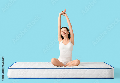 Young woman sitting on matt...