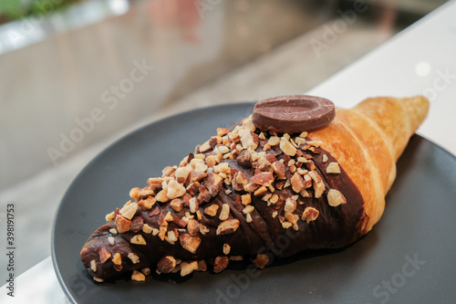 chocolate croissant on black dish in cafe