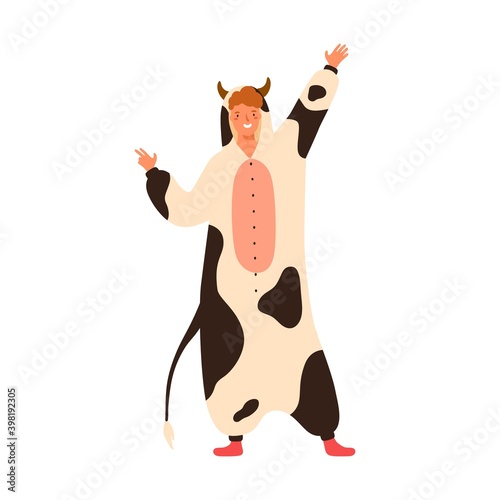 Funny young man dancing in cow kigurumi at carnival party. Male performer wea...