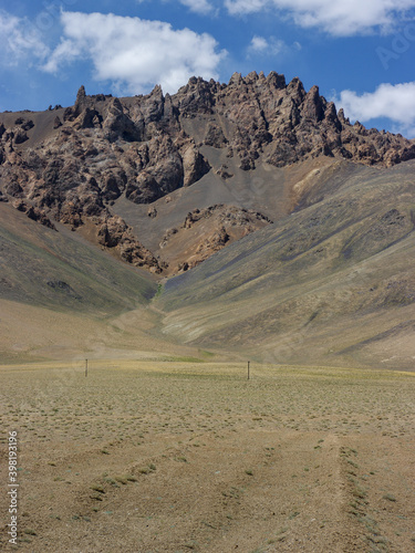 Vertical landscape view of spectacular rock formations along high-altitude Pamir Highway near Murghab, Gorno-Badakshan, Tajikistan photo