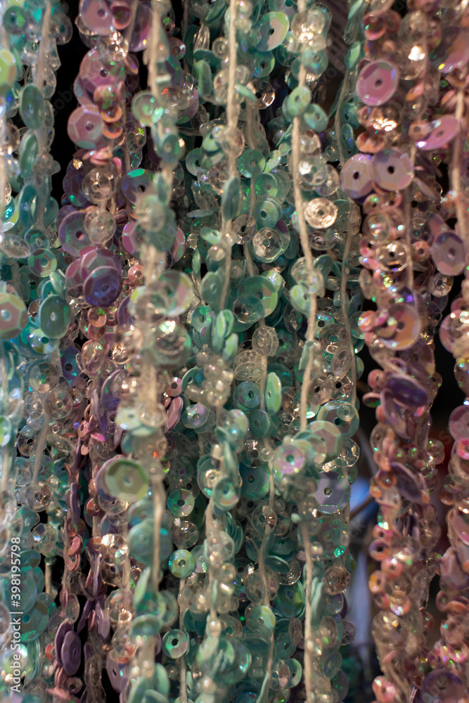 Naklejka premium Full frame photo of colorful buttons hanging at threads. Soft focus, shallow depth of field.