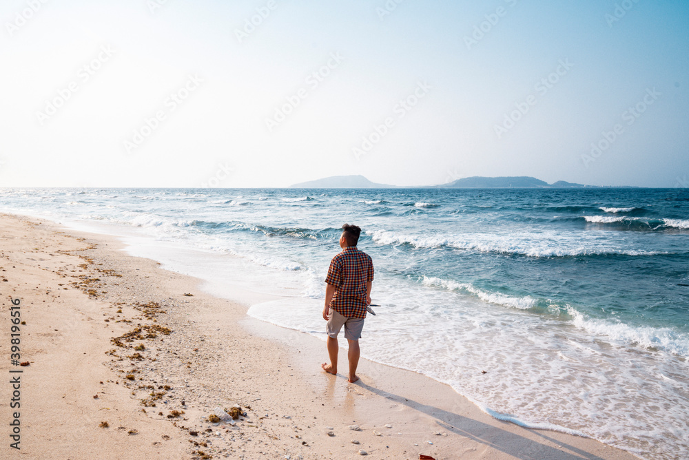 the man is walking alone on a ridge of jagged rock at Ly Son Island, Quang Ngai Province, Vietnam the man is walking alone on a ridge of jagged rock at Ly Son Island, Quang Ngai Province, Vietnam