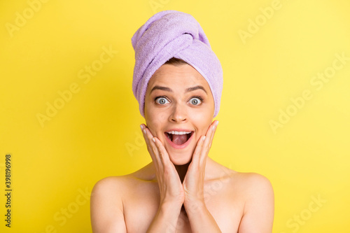 Close-up portrait of pretty amazed cheerful girl enjoying procedure fresh skin isolated over vivid yellow color background