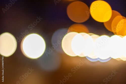 Out of focus defocused blurred bokeh of cars and traffic lights at night on city street.