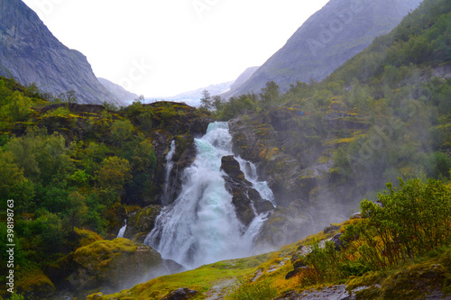 Beautiful waterfall in the Jostedalsbreen National Park in Norway. Pathway to Briksdal or Briksdalsbreen glacier in Olden. 