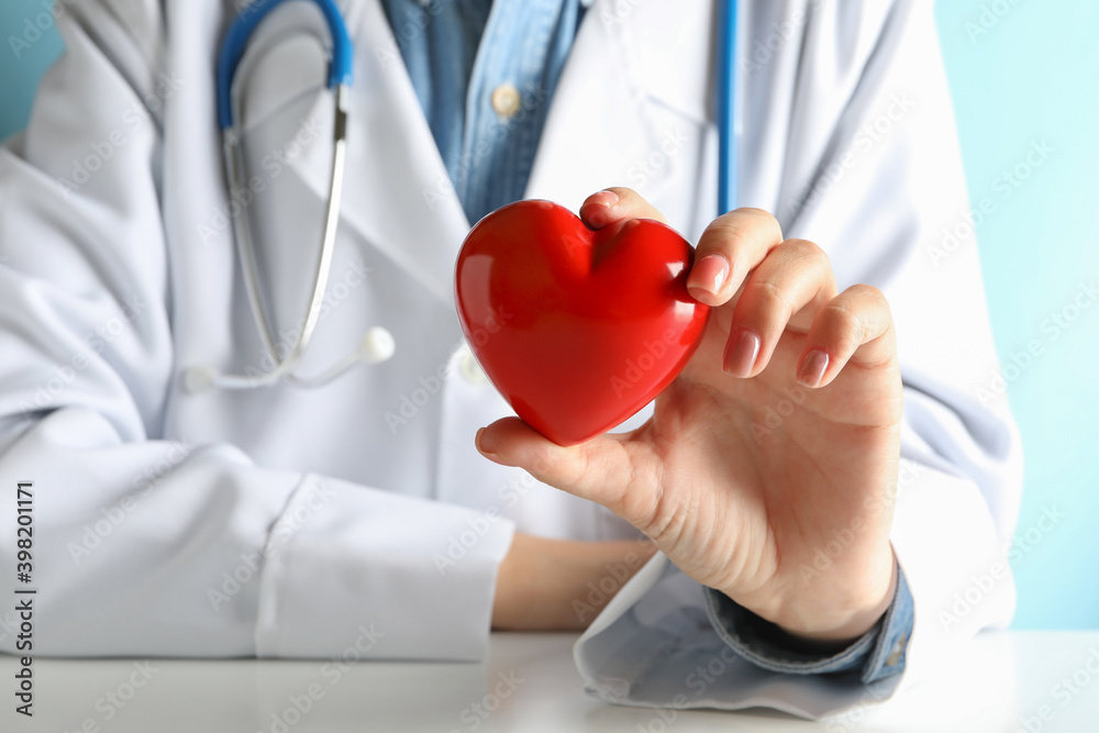 Female doctor with stethoscope holding red heart Female doctor with stethoscope holding red heart
