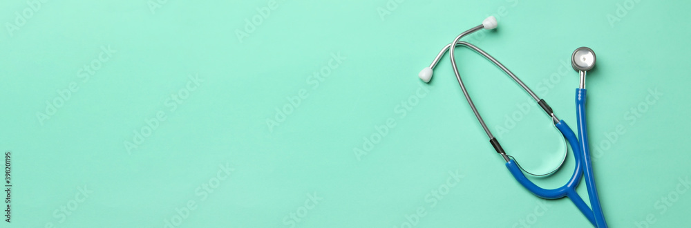 Blue stethoscope on mint background, space for text Blue stethoscope on mint background, space for text
