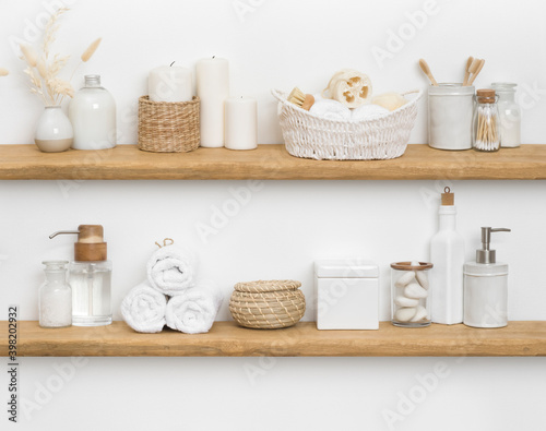 Body care cosmetics with spa accessories arranged on wooden shelves