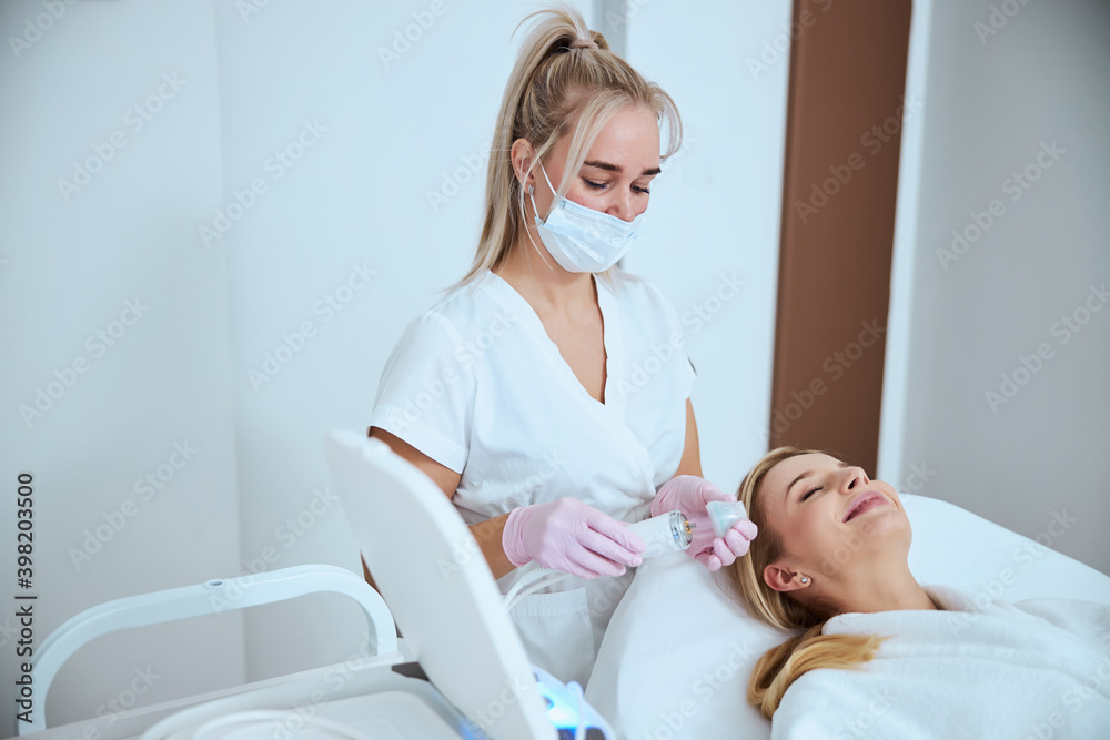Focused dermatologist preparing for treating her patient Focused dermatologist preparing for treating her patient