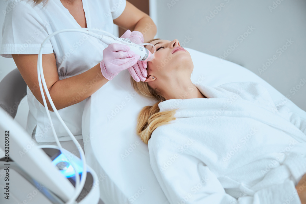 Blonde woman getting a skin tightening treatment Blonde woman getting a skin tightening treatment