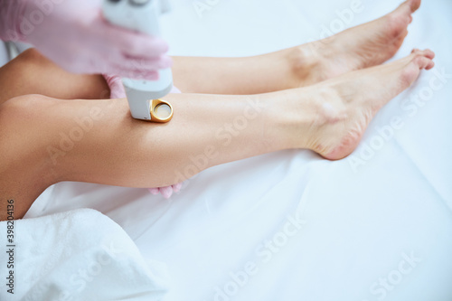 Dermatologist performing the laser hair removal treatment photo