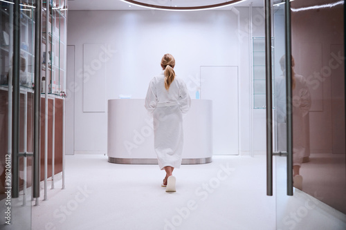 Slender woman with a ponytail heading towards the reception desk photo