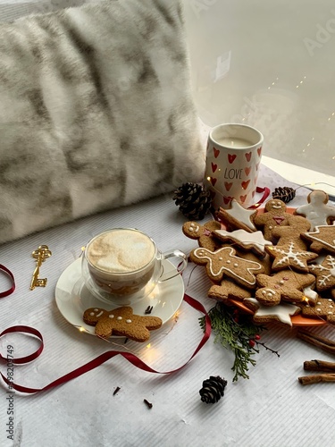 Hot winter drink: chocolate with whipped cream in glass mug. Christmas time. Cozy home atmosphere, white background. Homemade gingerbread cookies, christmas lights. Banner, copy space for text
