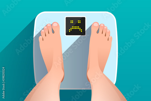 Feet of woman standing on bathroom scales with unhappy face on display