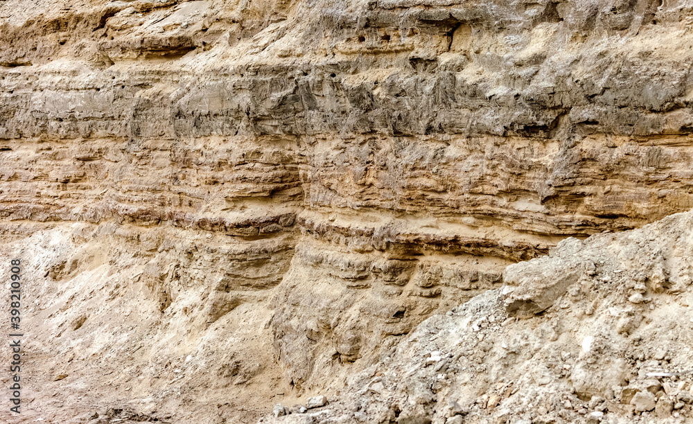 Obraz premium A precipitous wall of gray-brown sand in autumn. Background